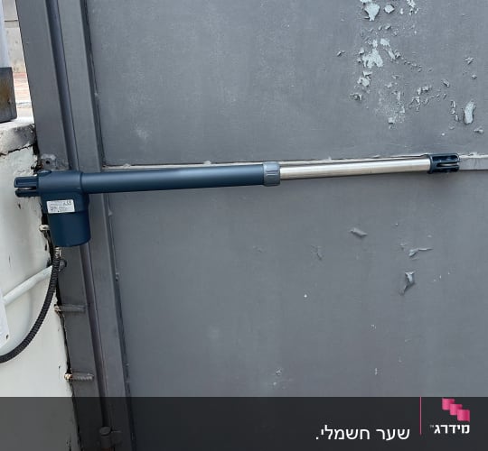 מנוע חשמלי לשער מתכת אפור עם שלט אזהרה